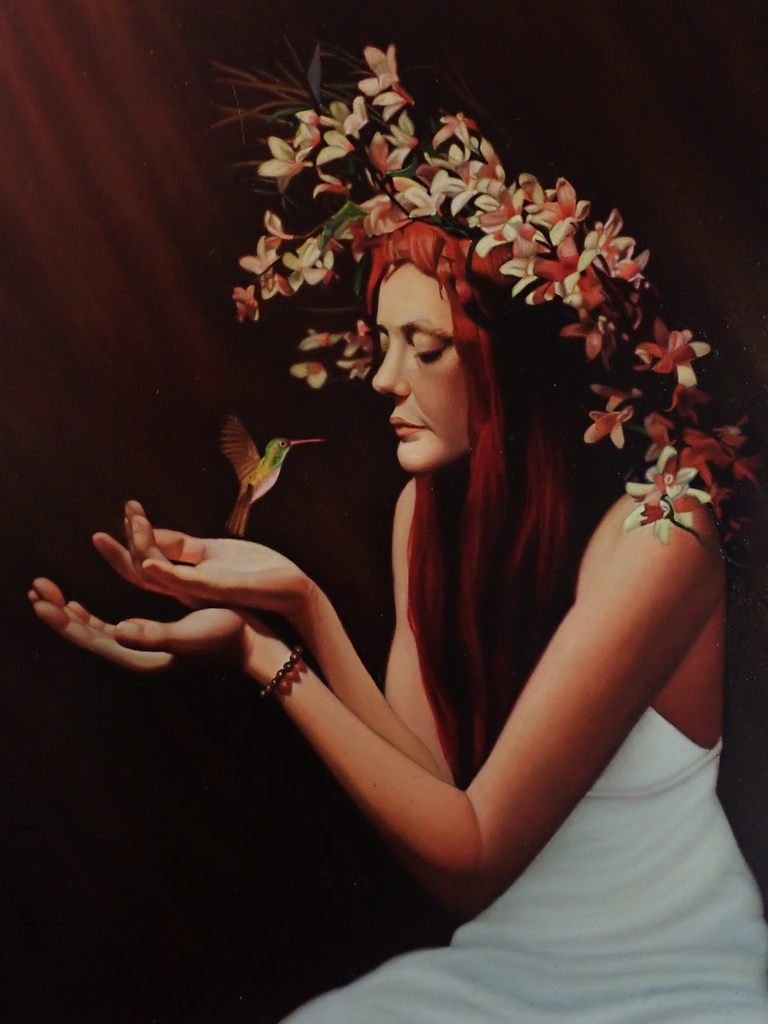 Oil painting of a red-haired woman in a crown of blossoms holding out her hands to a hummingbird